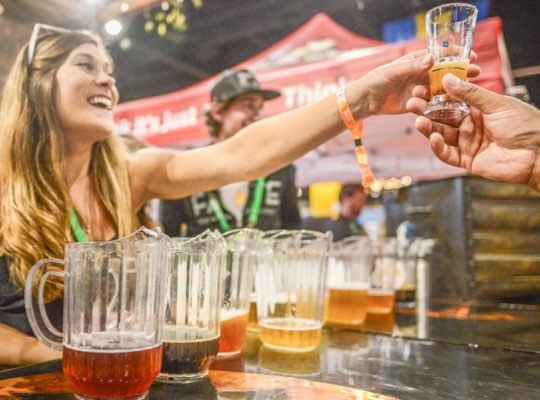 woman-serving-colorful-craft-beer-samples-at-great-american-beer-festival-min